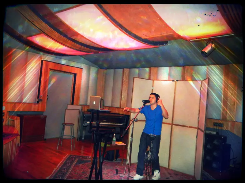 MC Solar Wind recording in a vocal booth in San Francisco