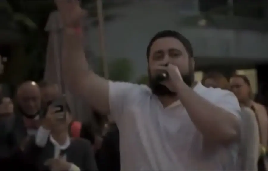 MC Solar Wind with his hand raised, performing at the premiere